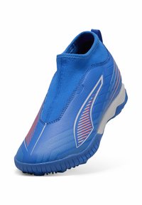 Scarpa sportiva blu con una vestibilità aderente e senza lacci. Presenta una tomaia elastica, motivi testurizzati e una suola in gomma con scanalature per la trazione.