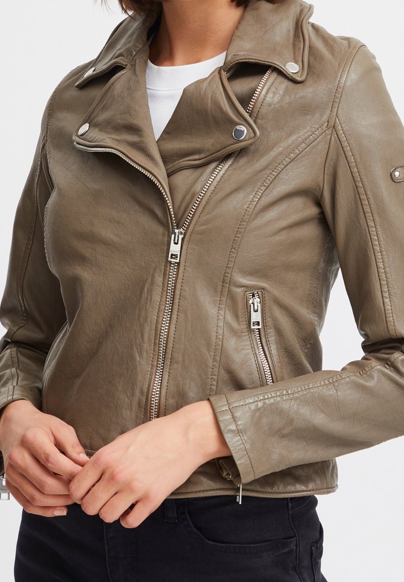 Veste de moto en cuir vert olive avec fermetures éclair argentées, col cranté et coupe ajustée. Comprend des poches zippées et une finition texturée.