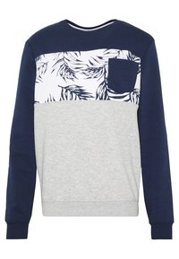 Sudadera azul marino y gris con un panel superior estampado que presenta hojas de palma y un pequeño bolsillo en el lado izquierdo. Estilo casual, de manga larga.