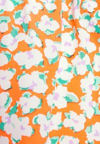 Blomstret stof med hvide blomster, grønne blade og lavendelnuancer på en orange baggrund. Blød tekstur, let materiale.