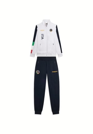 Tuta bianca e blu navy con strisce della bandiera italiana, scritta "ITA", logo Freddy e tasche con zip su giacca e pantaloni.