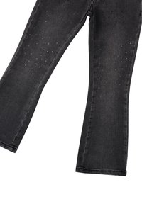 Pantalones de mezclilla negros acampanados con una textura suave, adornados con tachuelas metálicas dispersas y un diseño clásico de cinco bolsillos.