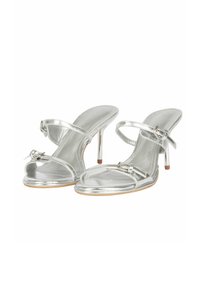 Sandali con tacco alto in metallo argentato, dotati di due sottili cinturini e una fibbia decorativa. Design aperto sulla punta, con una texture liscia e un tacco slanciato.