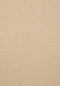 Beige vævet stof med et tekstureret, zigzag-mønster. Materialet fremstår naturligt og blødt, velegnet til forskellige anvendelser.