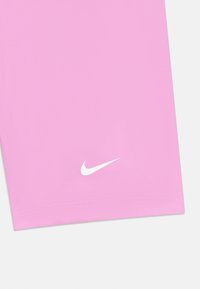 Rode sportieve shorts van gladde stof, met een witte Nike-logo nabij de zoom. Standaard stiksels langs de randen.