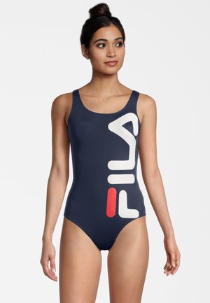 Bañador de una pieza color azul marino, fabricado en una tela suave, que presenta un gran logo de FILA en blanco y rojo en la parte frontal y tirantes anchos.