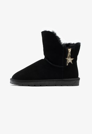 Czarne zamszowe botki za kostkę z teksturowaną powierzchnią, wyłożone futrem, z bocznym zamkiem błyskawicznym oraz złotą zawieszką w kształcie gwiazdy. Płaska gumowa podeszwa.