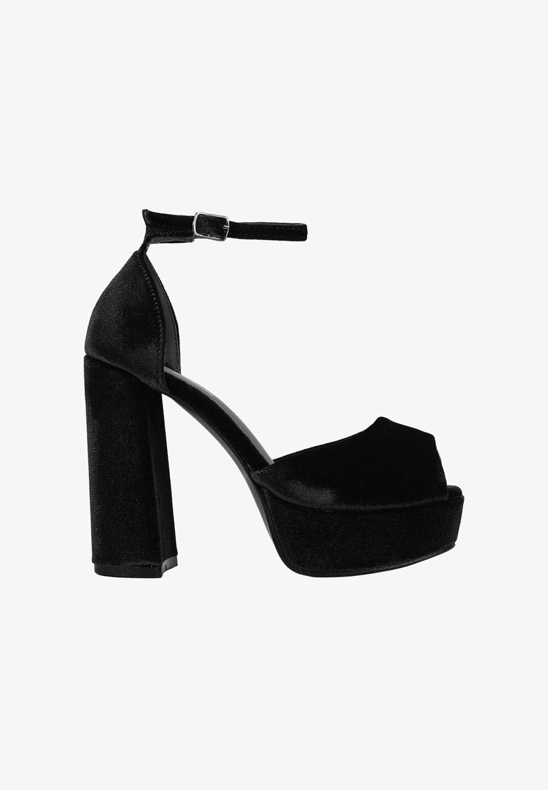 Tacón de plataforma de terciopelo negro con punta abierta redondeada y tira en el tobillo, que presenta un tacón bloque grueso para mayor estabilidad y un diseño elegante.