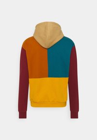 Hoodie met een color-block ontwerp, met oranje, turquoise, gele en bordeauxrode secties. Katoenen materiaal, zachte textuur.