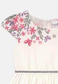Hihaton mekko, jossa on kukkakuosi vaaleanpunaisena, purppurana ja harmaana. Kermaisen värinen kangas sisältää hopeisen vyötärönauhan ja vetoketjun takana.