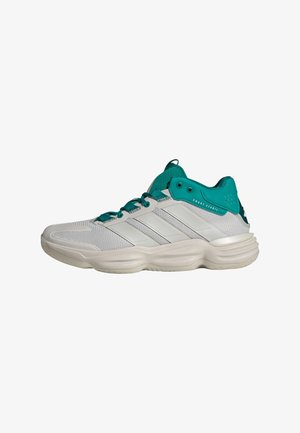 Sneaker sportiva bianca e turchese bassa con tomaia in mesh, suola imbottita e scritta "Court Stabil" vicino al collarino della caviglia, vista laterale sinistra.