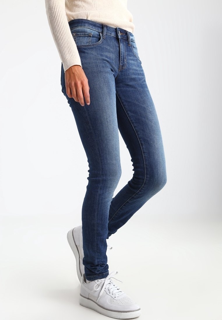 Jeans ajustados de denim en color azul, con una cintura de altura media, diseño clásico de cinco bolsillos y un ligero desvanecimiento para aportar textura.