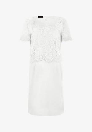 Witte jurk met korte mouwen, bloemenkantlaag op het lijfje en de mouwen, en een golvende zoomdetail aan de bovenste laag.