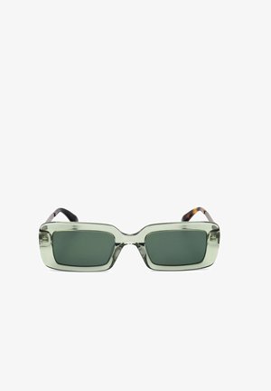 Occhiali da sole rettangolari con lente verde, montatura spessa trasparente verde e lenti scure, visti frontalmente.