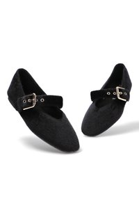 Bailarinas negras de punta afilada con textura peluda y una correa con una hebilla plateada en la parte superior.