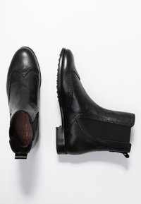 Mustat nahkaiset nilkkurit, joissa on joustavat sivupaneelit, pyöreä kärki, koristeompeleet ja tasainen kumipohja, jossa on pienet niitit.