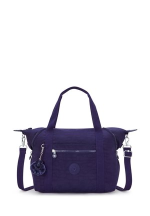 Sac en tissu violet avec deux poignées et une bandoulière amovible. Comprend une poche zippée et un charme en fourrure attaché. Fini texturé.