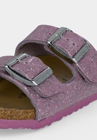 Μωβ σανδάλι με υφή φελλού, δύο μεγάλες ρυθμιζόμενες ασημένιες αγκράφες και περιμετρικό πέλμα.