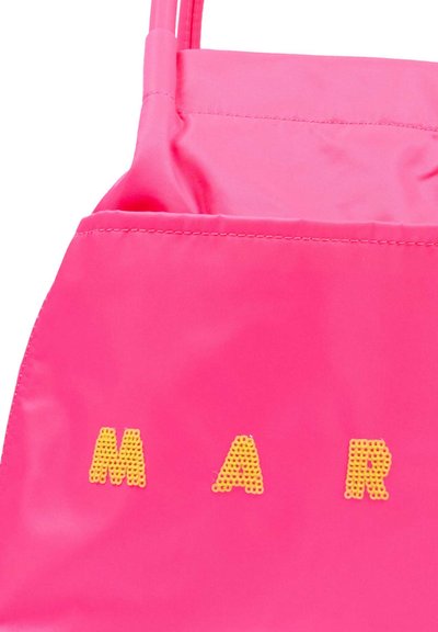Svetlo roza ročna torbica iz tkanine z rumenimi bleščečimi črkami "M A R" na sprednji strani in ozkim trakom na vrhu.