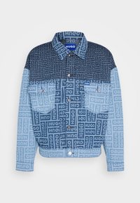 Kurtka jeansowa w jasnoniebieskim i ciemnoniebieskim odcieniu z dwoma fakturami materiału. Z nadrukiem "HUGO" powtarzającym się w wzorze, dwoma przednimi kieszeniami i zatrzaskami.