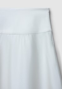 Jupe blanche avec une texture lisse, une taille haute et une fermeture éclair dissimulée sur le côté. Le tissu semble léger et fluide.