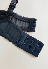 Mørkeblå bh-stropper og -bånd har glat stof, meshindsatser og kroge til justering. Dekorativ trim tilføjer subtil detalje.