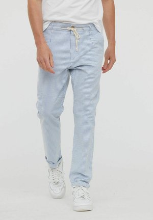 Pantalons légers rayés bleu clair et blanc, dotés d'une taille élastique avec cordon de serrage. Tissu en coton, conception slim fit.