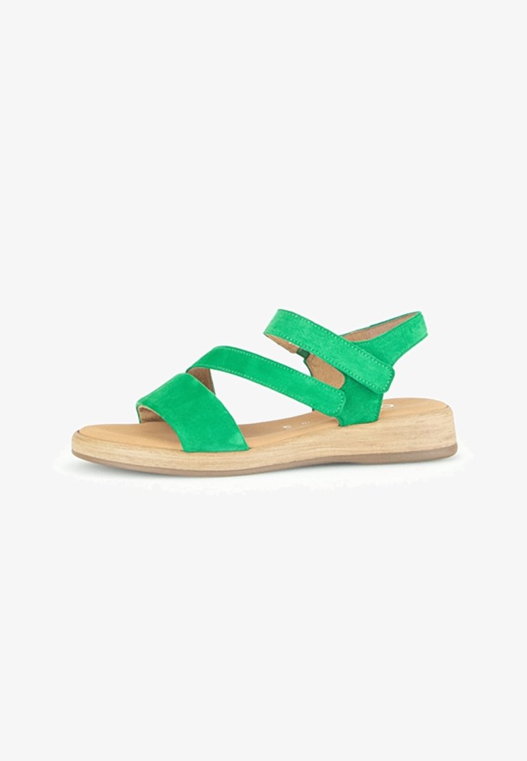 Sandale en daim vert pour femme avec trois brides et une semelle plate en bois clair, vue de côté sur fond blanc.