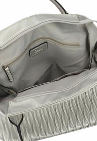 Sac à main argenté avec un extérieur texturé et plissé et un intérieur lisse et doublé. Comprend une petite poche zippée et une étiquette à l'intérieur.