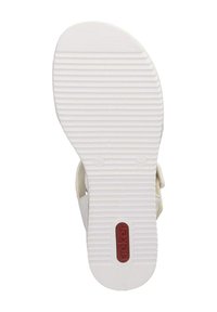Sole bianca di un sandalo con scanalature testurizzate, caratterizzato da un cinturino marrone chiaro e da un logo rosso incorporato vicino al tallone.