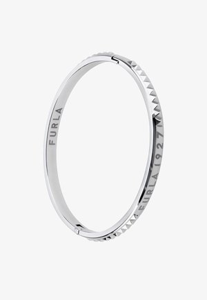 Strieborný náramok má hladký povrch so pyramídovými hrotmi pozdĺž okraja, na jednej strane je vyrytý nápis "FURLA 1927".