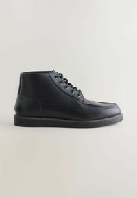 Czarne skórzane wysokie buty z sznurowadłami, teksturowana powierzchnia, gruba podeszwa i widoczne szwy, przedstawione w profilu bocznym na neutralnym tle.