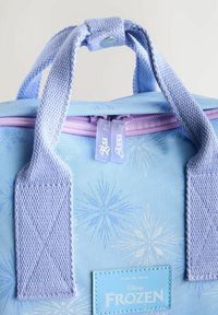Sac à dos bleu clair avec un motif de flocons de neige, des fermetures à glissière violettes, des bretelles texturées et une étiquette bleue avec "Disney Frozen".