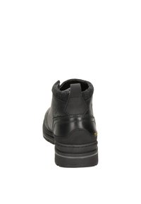 Zwarte leren enkelboot met een gestructureerde wollen rand, ronde neus en stevige rubberen zool. Beschikt over minimale stiksels en een lusvormige trekband.