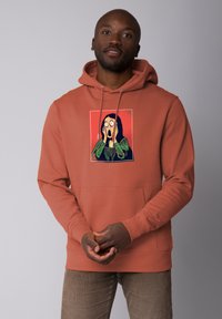 Roodbruin pullover hoodie met een grafiek van een schreeuwende figuur. Gemaakt van zachte stof, het heeft een kangoeroezak en een capuchon met trekkoord.