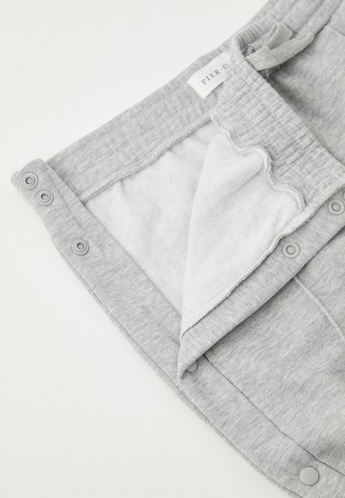 Pantalons de survêtement gris avec un intérieur doux et doublé en polaire. Taille élastique avec cordon de serrage ajustable et boutons-pression.