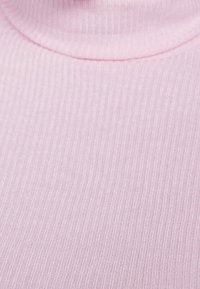 Růžový žebrovaný rolák s jemnou texturou, s vertikálními pruhy a přiléhavým designem kolem krku.