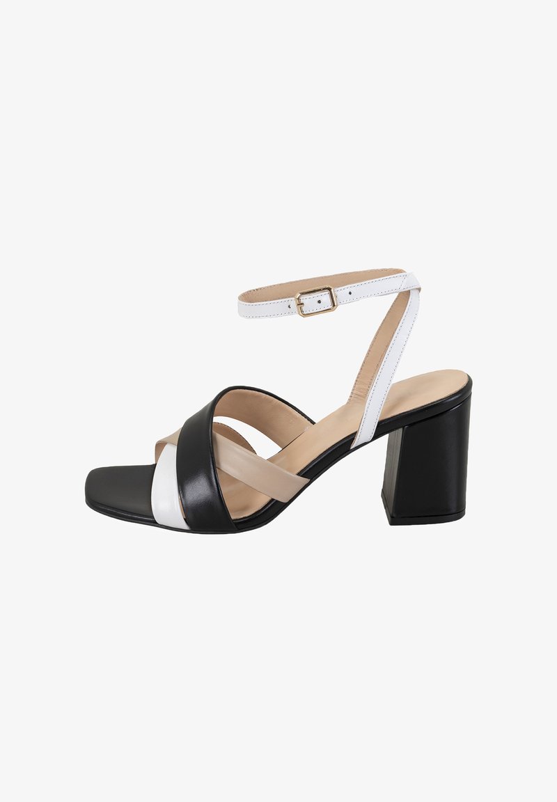 Sandales à talons carrés en cuir noir et blanc avec un orteil carré, dotées de brides entrecroisées et d'une sangle de cheville réglable.