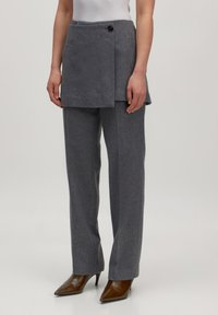 Grijze wolmix cropped rok over een bijpassende broek, met een sluiting aan de zijkant en een gestructureerde pasvorm. Hakken met een puntige neus maken de look compleet.