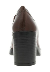 Chaussure à talon compensé en cuir brun avec une semelle noire texturée, bout pointu et finition lisse. Coutures visibles le long des coutures.