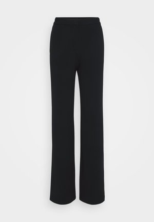 Pantalon large noir en tissu doux et texturé, avec une taille lisse et sans fermetures ni accents visibles. Design simple et polyvalent.