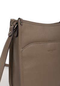 Borsa a spalla in pelle marrone con finitura texturizzata, tracolla scura a contrasto e logo impresso. Presenta un design elegante e minimalista.