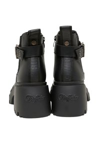 Botas negras hasta el tobillo con una suela de plataforma gruesa, parte superior de piel texturizada, dos correas con hebilla y detalles de logotipo embossado en el tacón.
