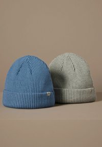 Due cappelli a coste, uno blu e uno grigio chiaro. Ognuno presenta un bordo piegato e un piccolo tag chiaro con un accento a forma di stella.