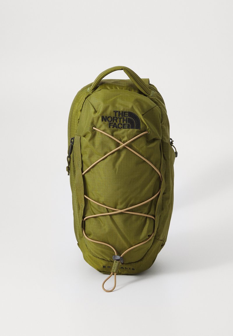 Zielony nylonowy plecak o teksturowej powierzchni, z elastycznym sznurkiem z przodu, kieszeniami bocznymi i czarnym logo North Face.