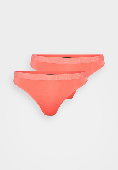 Coral-colored thong underwear with a soft texture, featuring a wide waistband embossed with "Emporio Armani" logo in contrasting color.