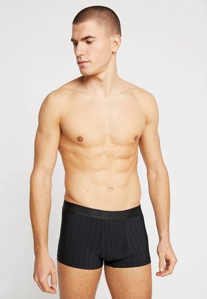 Boxer-briefs noirs avec une texture côtelée, dotés d'une ceinture élastique noire avec un logo. Le tissu a l'air doux et ajusté.