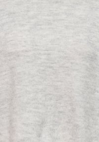 Tissu en tricot gris clair avec une texture douce. Motif subtil de petites taches plus foncées, présentant une finition lisse et une apparence uniforme.