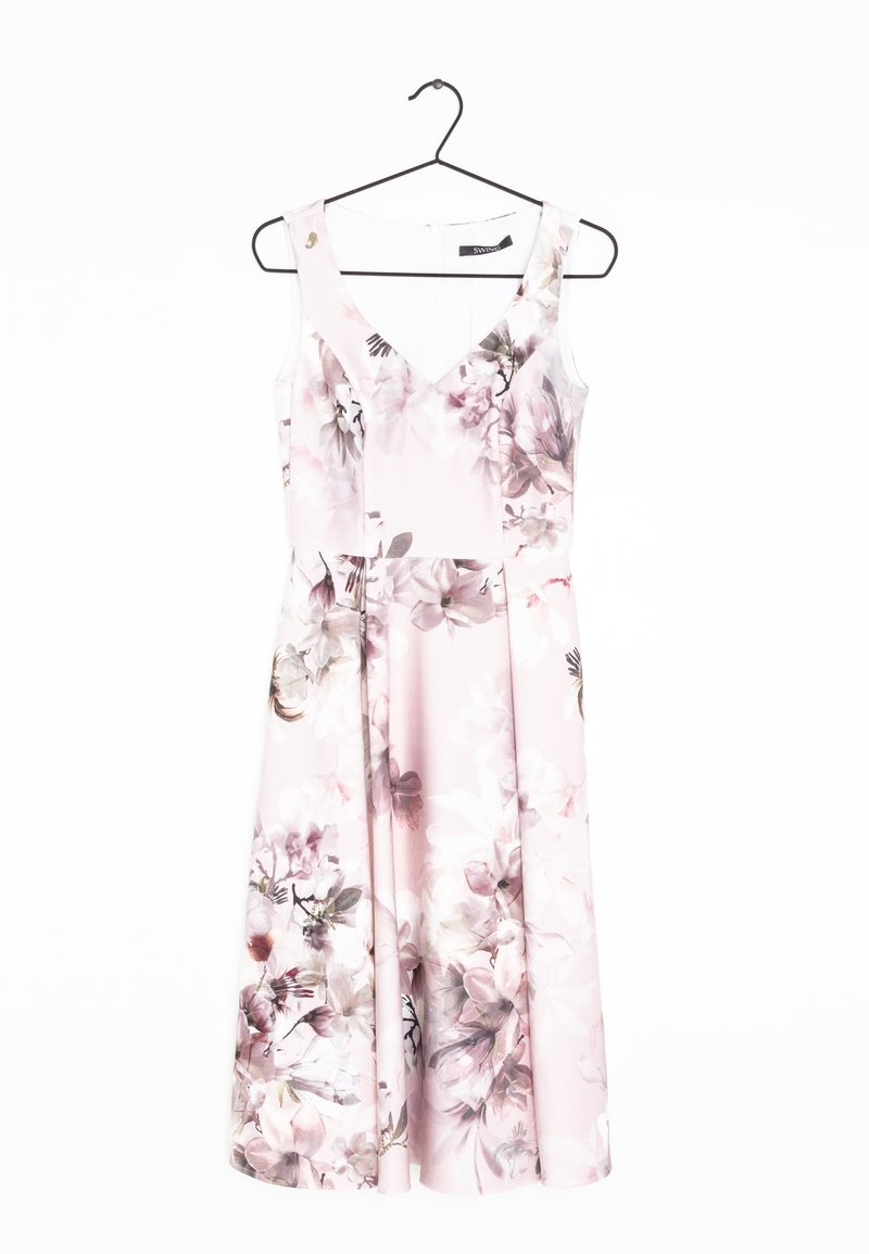 Robe rose pastel sans manches à imprimé floral, col en V et taille cintrée, suspendue sur un cintre noir sur fond blanc.