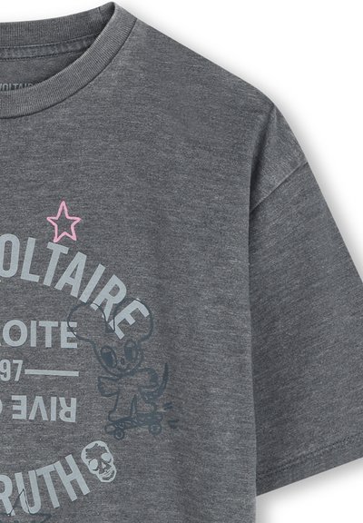 T-shirt en coton gris avec un col rond, présentant des impressions graphiques en bleu et rose, dont un extraterrestre sur une planche à roulettes et des éléments de texte.
